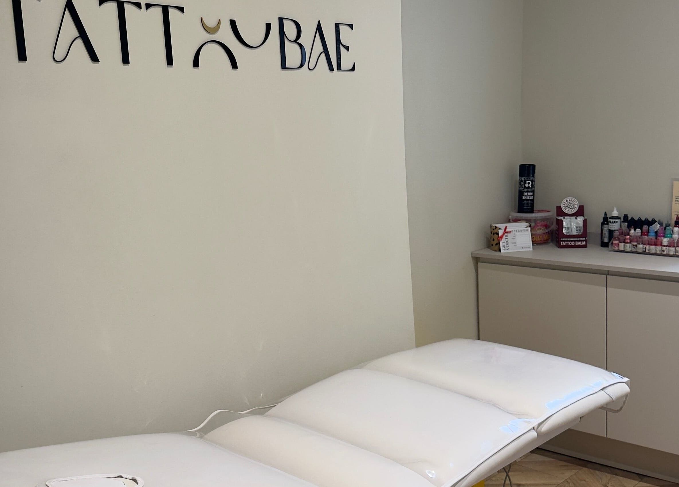 Tattoo station at TATTOOBAE in Bury, England, GB, featuring a white table and ink supplies.