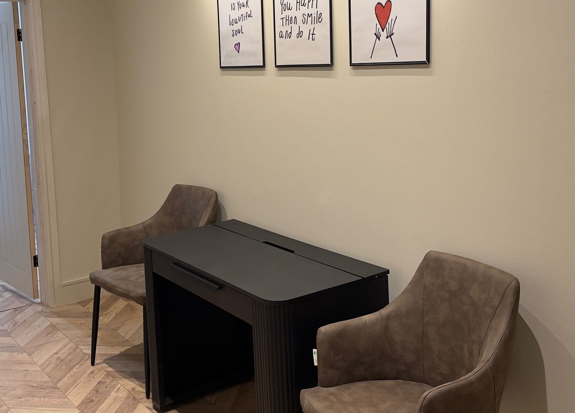 Artistic corner at TATTOOBAE with chairs and wall art, located in Bury, England, GB.