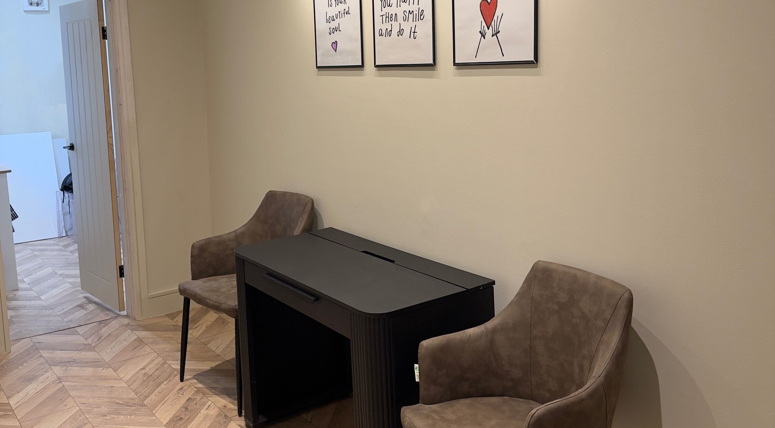 Artistic corner at TATTOOBAE with chairs and wall art, located in Bury, England, GB.