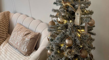 Elegant sofa and decorated Christmas tree at House of Glam in Newcastle upon Tyne, England, GB.