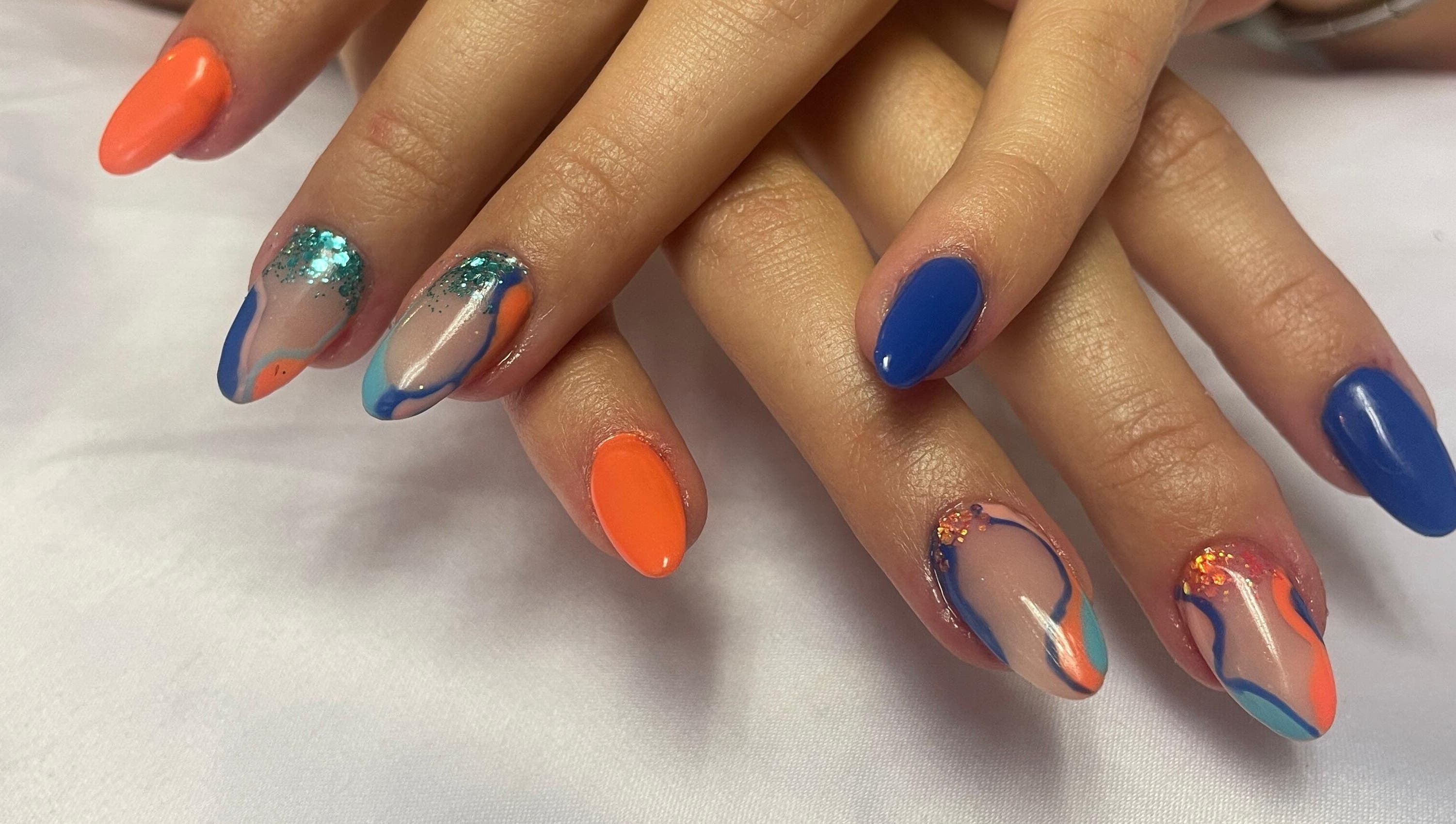 Colorful nail art at Cat's Claw Nails in Pretoria, Gauteng, ZA showcasing vibrant blue and orange designs.