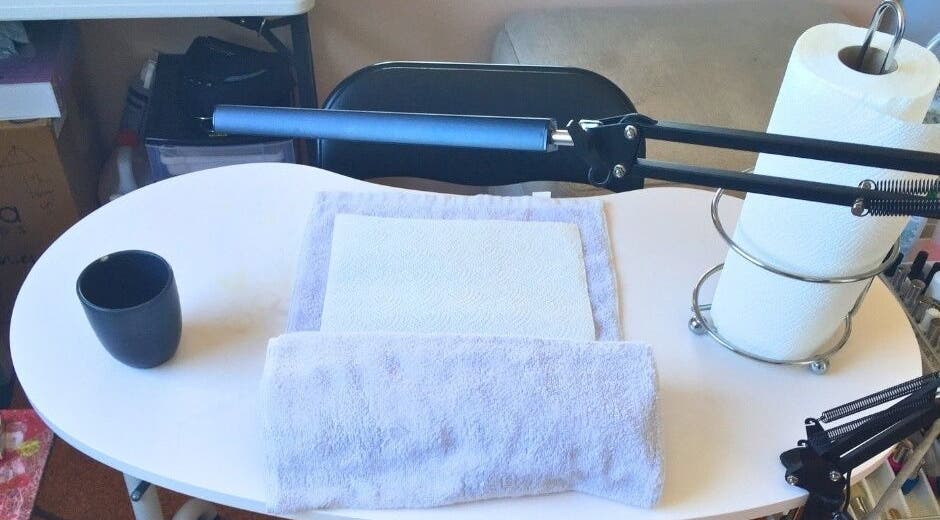 Organized nail station at MooMooCat Nails, Auckland, NZ, featuring towels and a lamp.