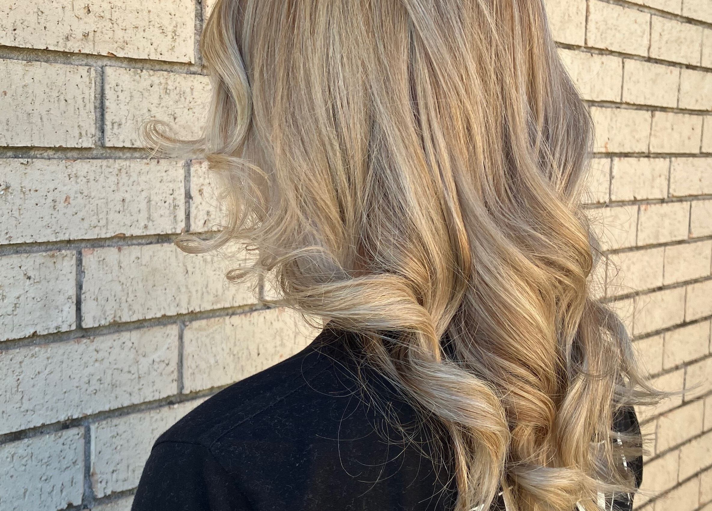 Blonde waves styled at Sammy Hair in Thornton, New South Wales, AU against a textured brick wall.