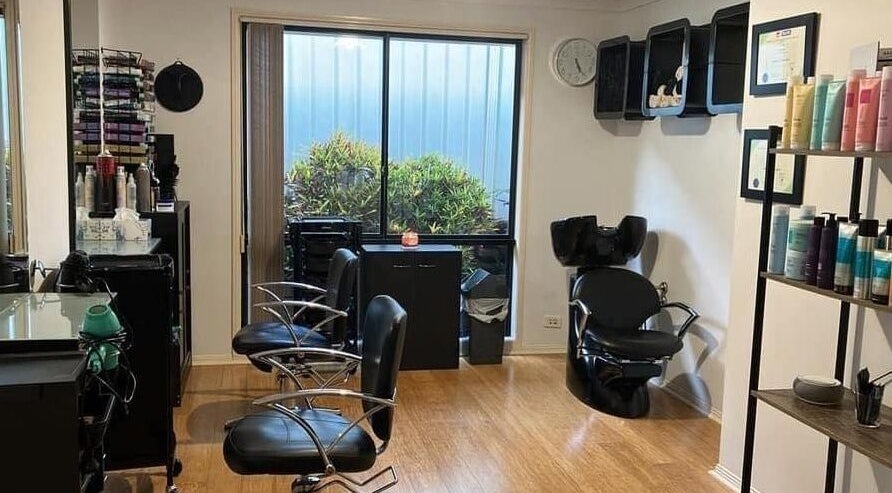 Inside Sammy Hair salon in Thornton, NSW, AU showcasing modern chairs and hair products by the window.