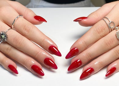 Glossy red nails with silver rings at Polished by Victoria, Redruth, England, GB.