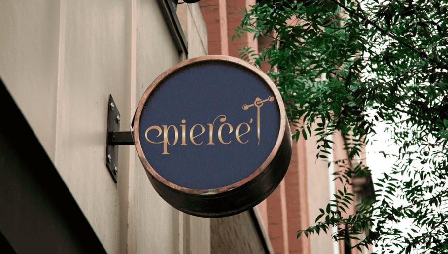 Elegant Pierce’T salon sign in Curaçao, CW, hanging on a building with leafy greenery.