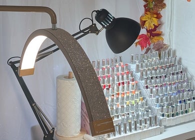 Nail polish display at Luxe Beauty by Rosie, Lowestoft. Elegant lamp and autumn decor create a cozy ambiance.