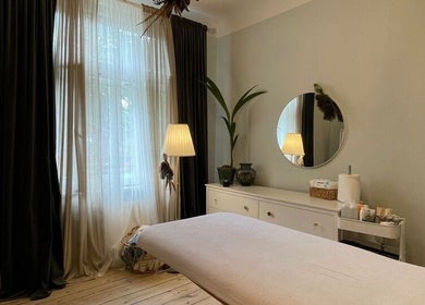 Relaxing treatment room at Tresor Beauty, Rīga, LV with a massage table, plants, and soft lighting.