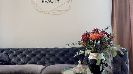 Elegant lounge area at Tresor Beauty in Rīga, LV with plush sofa and floral decor.