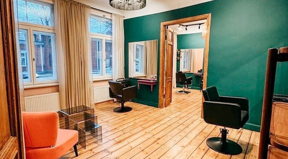 Inviting salon at Tresor Beauty, Rīga, LV, featuring stylish chairs and elegant decor in warm tones.