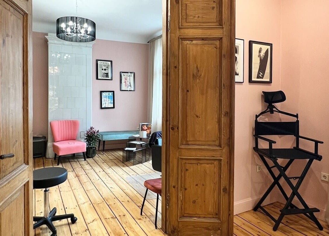 Elegant interior of Tresor Beauty in Rīga, LV with a pink chair and stylish decor, showcasing a serene ambiance.