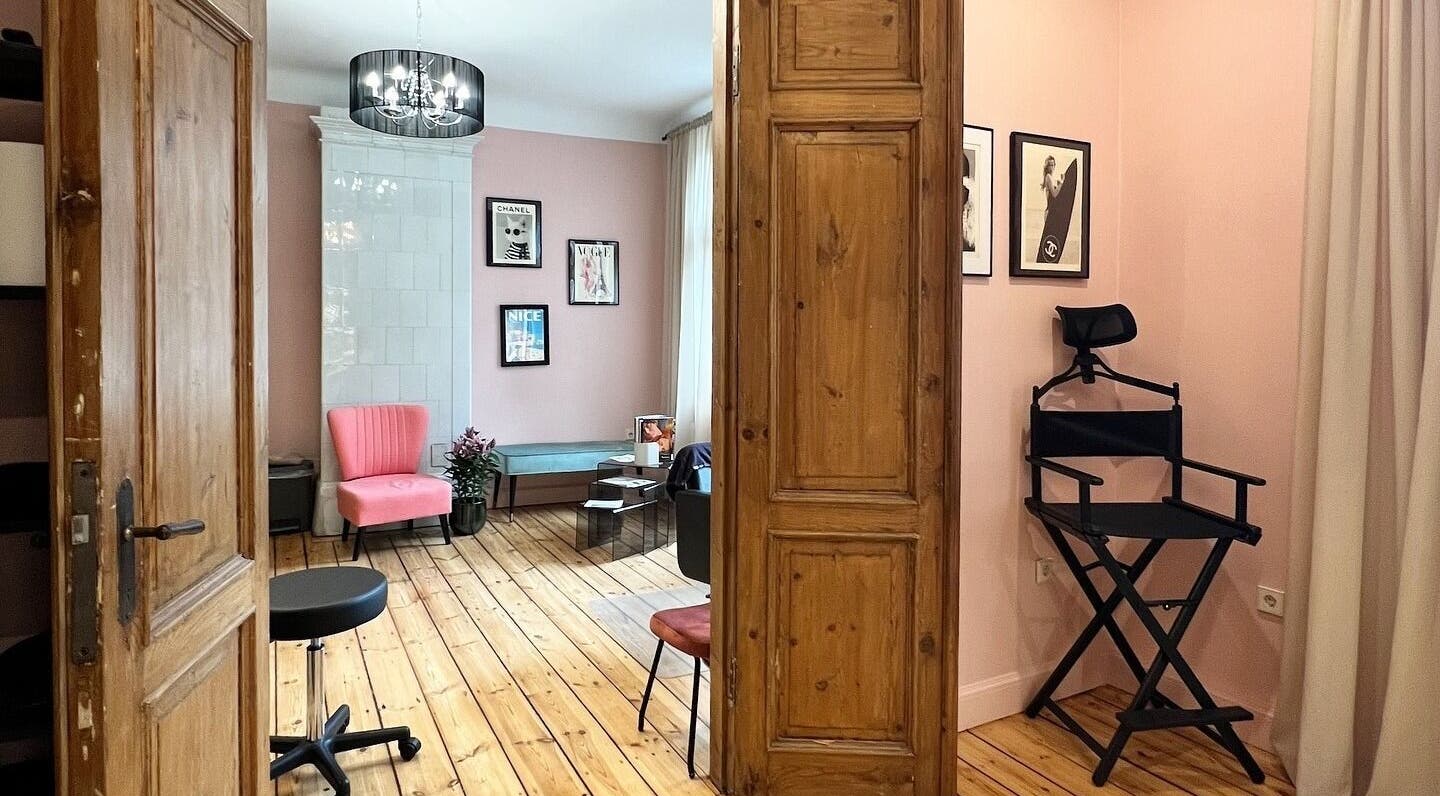 Elegant interior of Tresor Beauty in Rīga, LV with a pink chair and stylish decor, showcasing a serene ambiance.