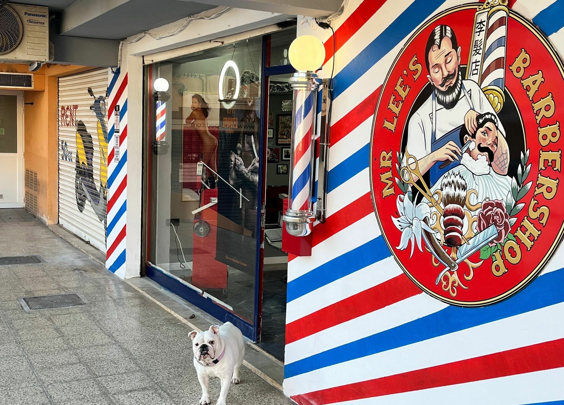 Entrance of Mr. Lee's Barbershop in Magaluf, Illes Balears, ES with iconic logo and barber pole.