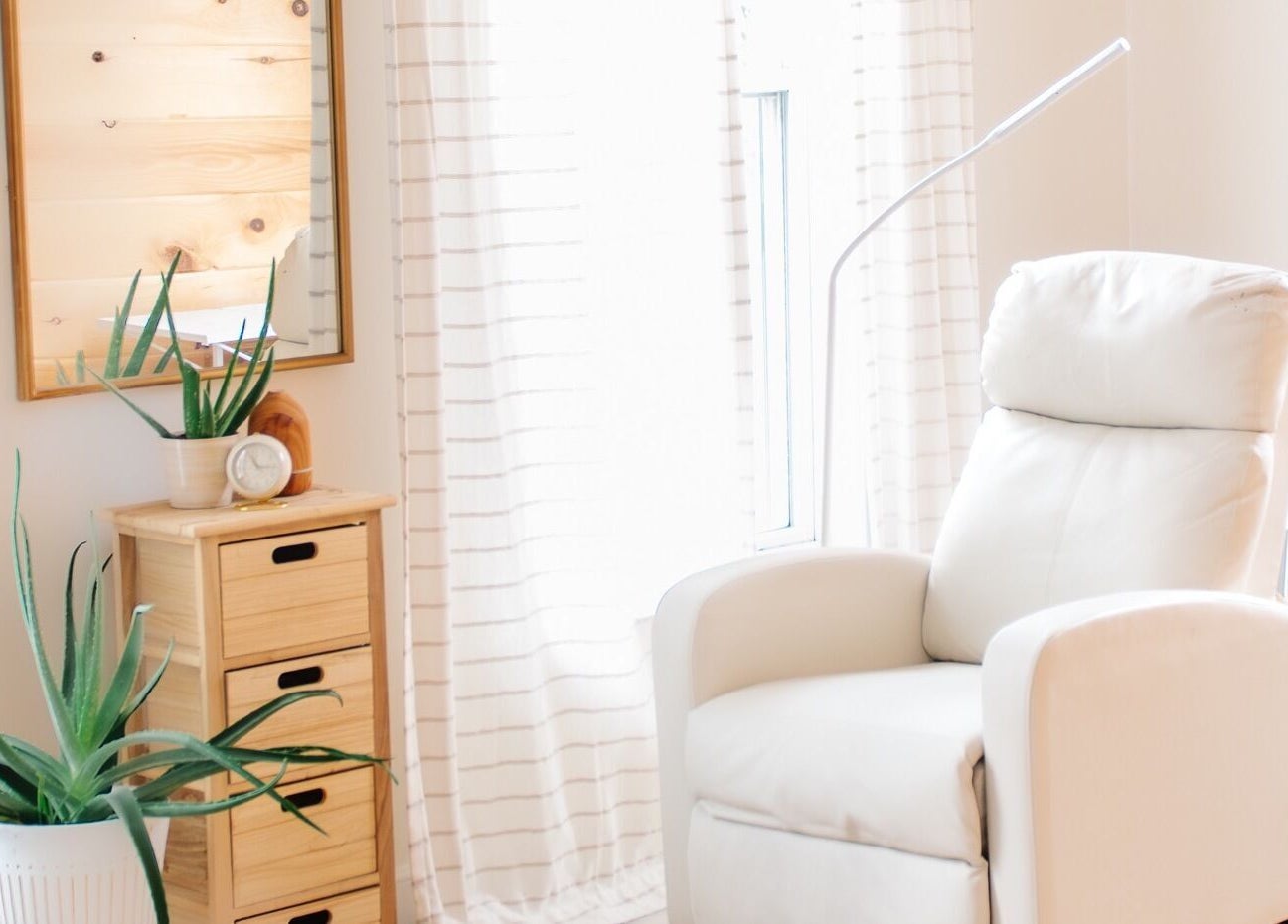 Cozy white relaxation chair in Lashed+ spa, Norwell, Massachusetts, US with natural decor and soft lighting.