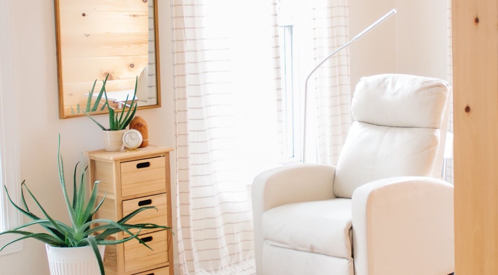 Cozy white relaxation chair in Lashed+ spa, Norwell, Massachusetts, US with natural decor and soft lighting.