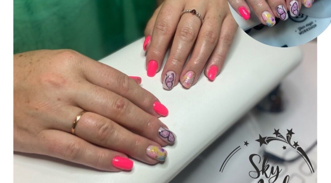 Elegant butterfly nail art at Sky 4 Nails, located in Poole, England, GB, showcasing vibrant pink designs.