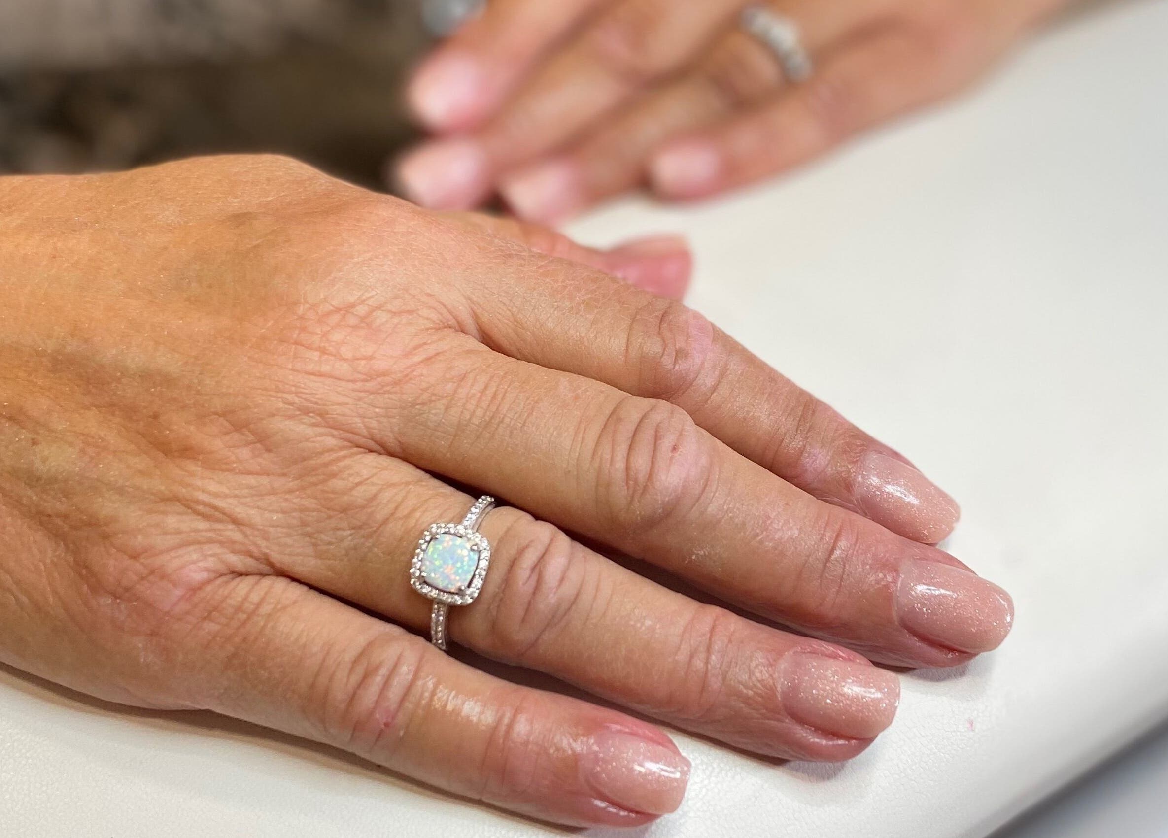 Manicured hands with rings at Sky 4 Nails, Poole, England, GB, showcasing elegant nail art.