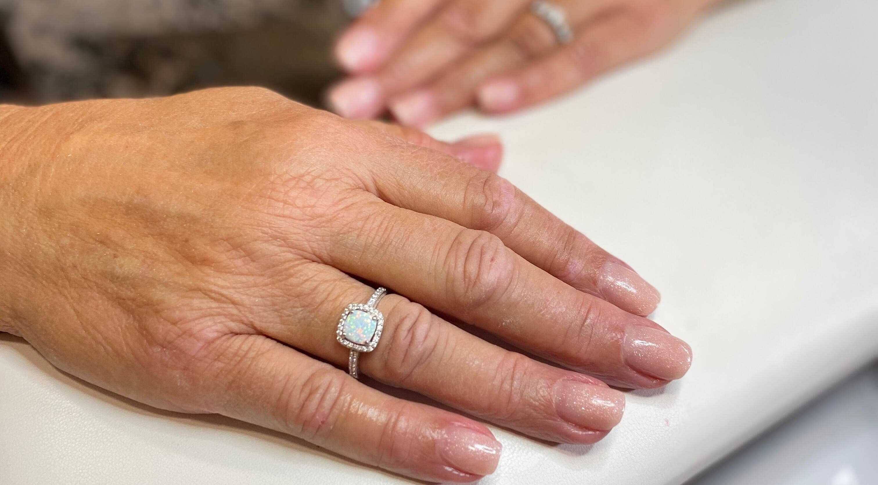 Manicured hands with rings at Sky 4 Nails, Poole, England, GB, showcasing elegant nail art.