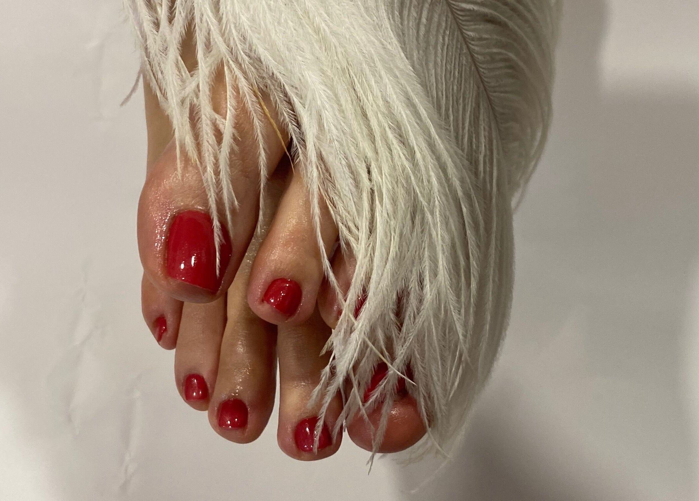 Beautiful red toenails with a feather accent at Sky 4 Nails, Poole, England, GB.