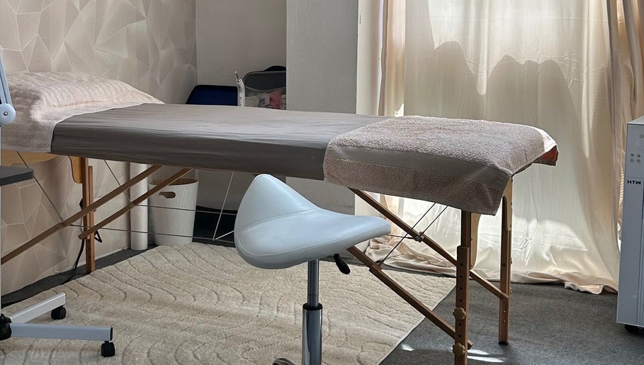 Sala de massagem no Centro Comercial Avenida, Coimbra, Coimbra, PT, com cama e cadeira moderna.