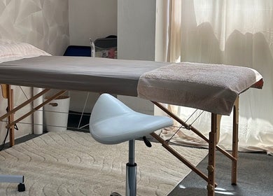 Sala de massagem no Centro Comercial Avenida, Coimbra, Coimbra, PT, com cama e cadeira moderna.