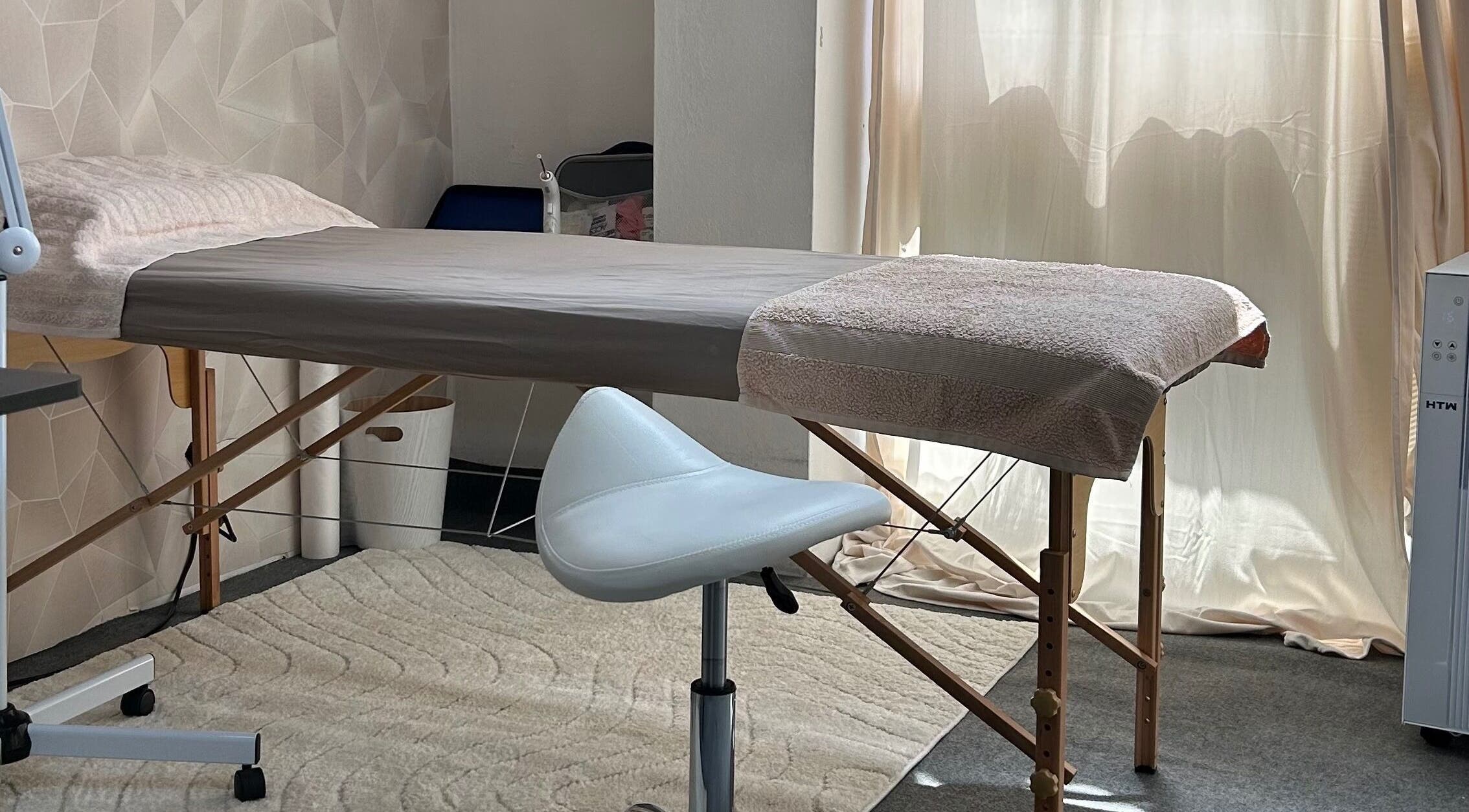 Sala de massagem no Centro Comercial Avenida, Coimbra, Coimbra, PT, com cama e cadeira moderna.