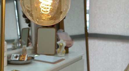 Sala iluminada da Santa Rosa Clinic em Mealhada, Aveiro, PT, com lâmpada decorativa dourada e espelhos.