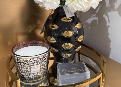 Elegant decor with candle and floral vase at The Salon Box, Brentwood, England, GB.