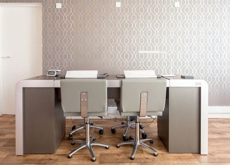 Modern reception desk and chairs at Lady A Clinic, Ayr, Scotland, GB with stylish wallpaper.