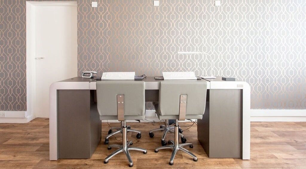 Modern reception desk and chairs at Lady A Clinic, Ayr, Scotland, GB with stylish wallpaper.