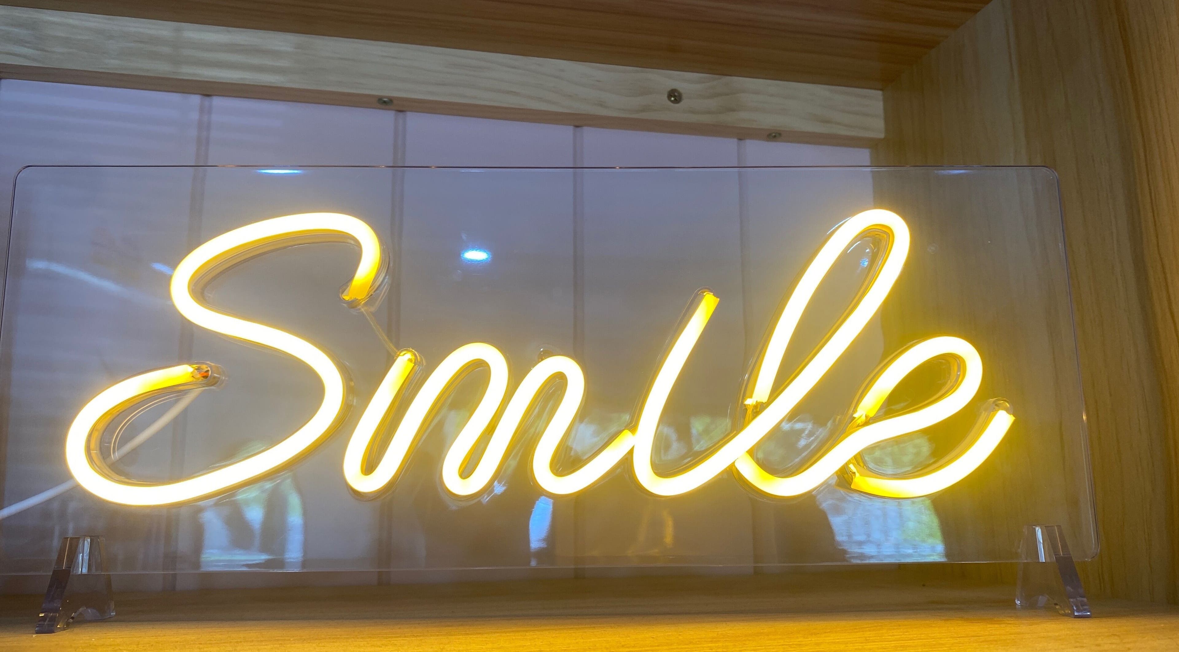 Neon smile sign at Jo Bailey Style, CURRUMBIN WATERS, Australia, AU, creating a welcoming ambiance.