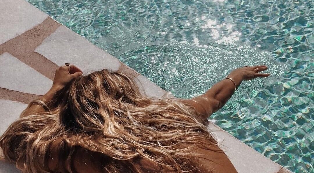 Relaxing by the pool at Minnelli Aesthetics in Johannesburg, Gauteng, ZA, featuring tranquil waters and sunshine.