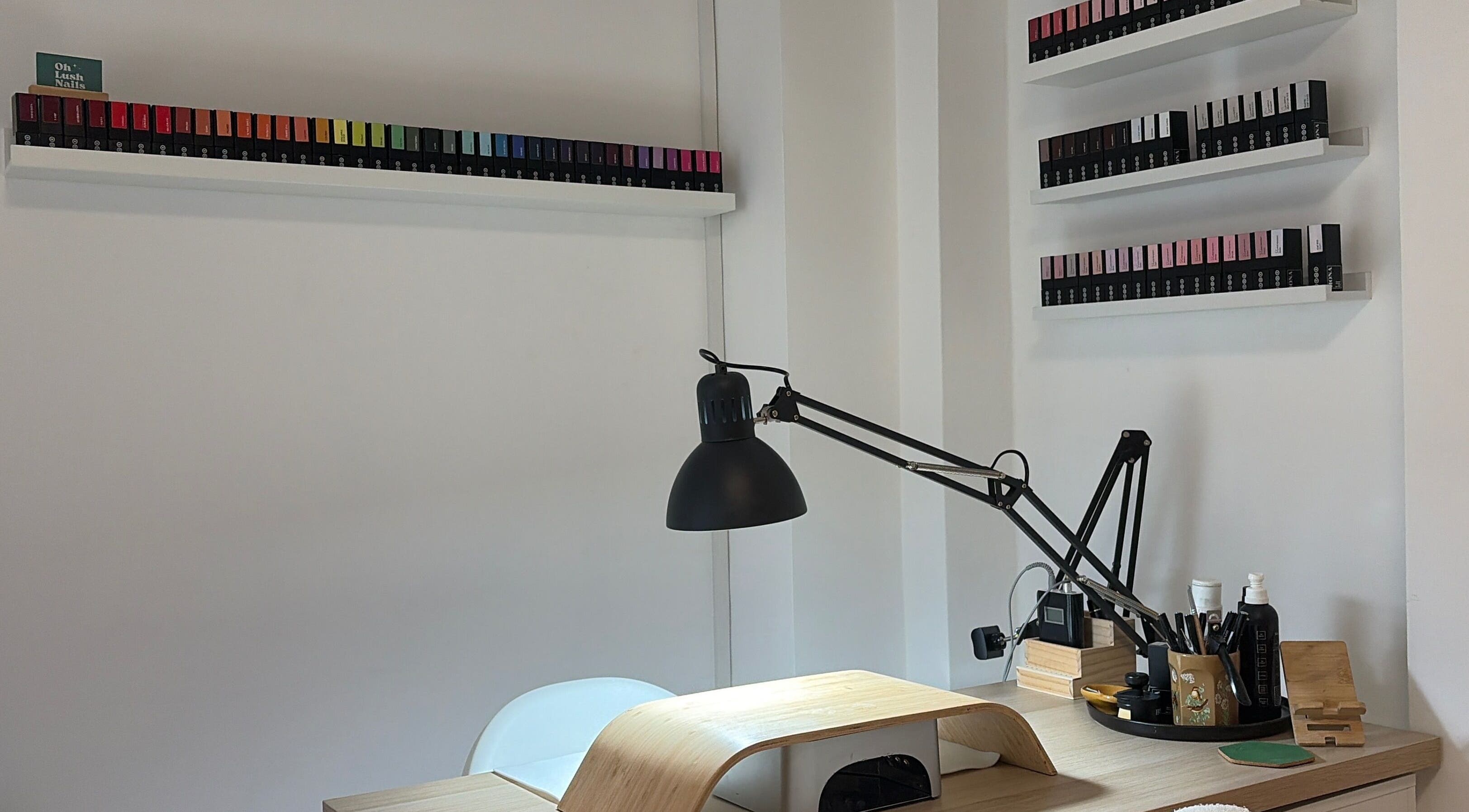 Nail treatment desk at Oh Lush Nails in Ystrad Mynach, Wales, GB, showcasing stylish polish collection.