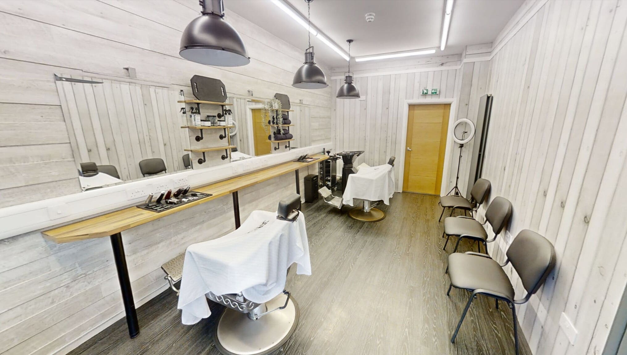 Bright and modern interior of Studio 4 Barbers in Saundersfoot, Wales, GB, featuring stylish barber chairs.
