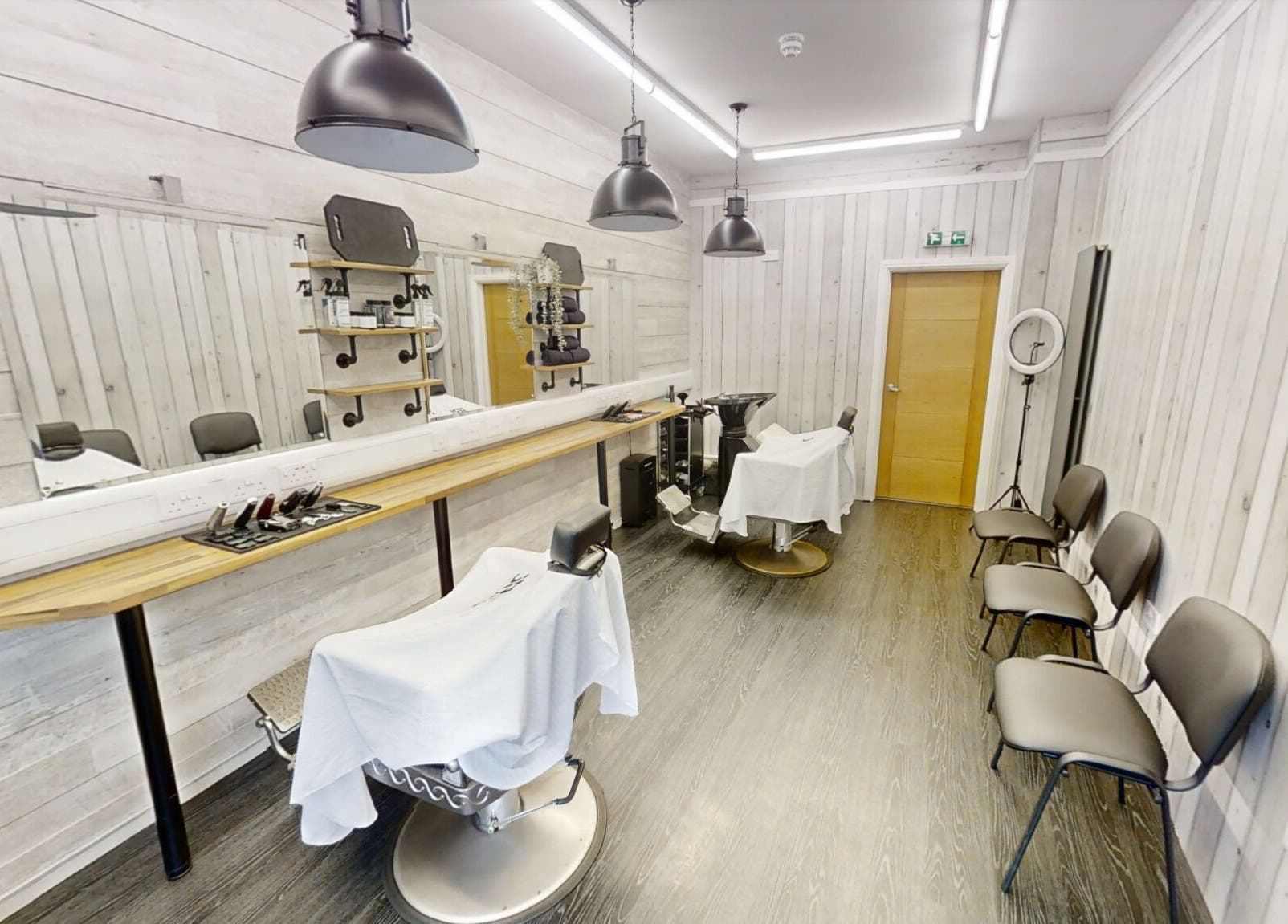 Bright and modern interior of Studio 4 Barbers in Saundersfoot, Wales, GB, featuring stylish barber chairs.