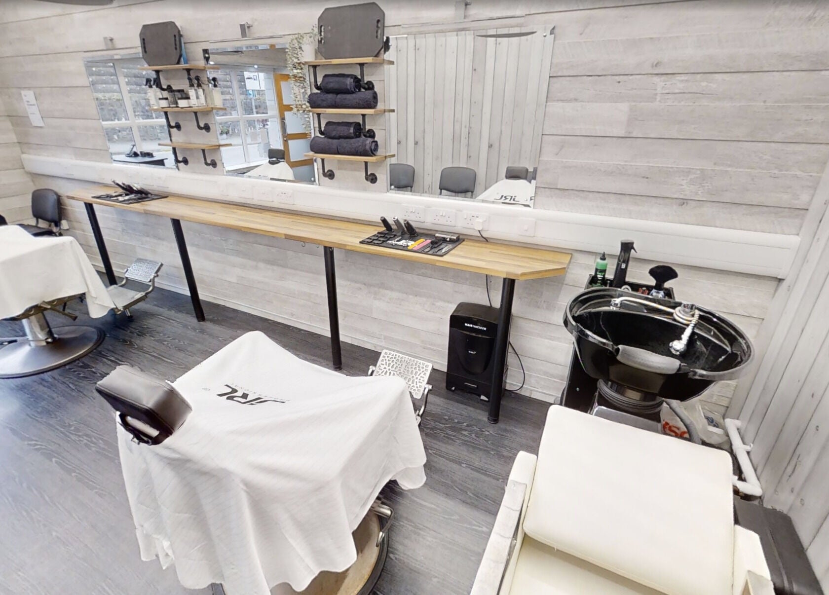 Modern interior of Studio 4 Barbers in Saundersfoot, Wales, GB. Features styling stations and sleek barber chairs.