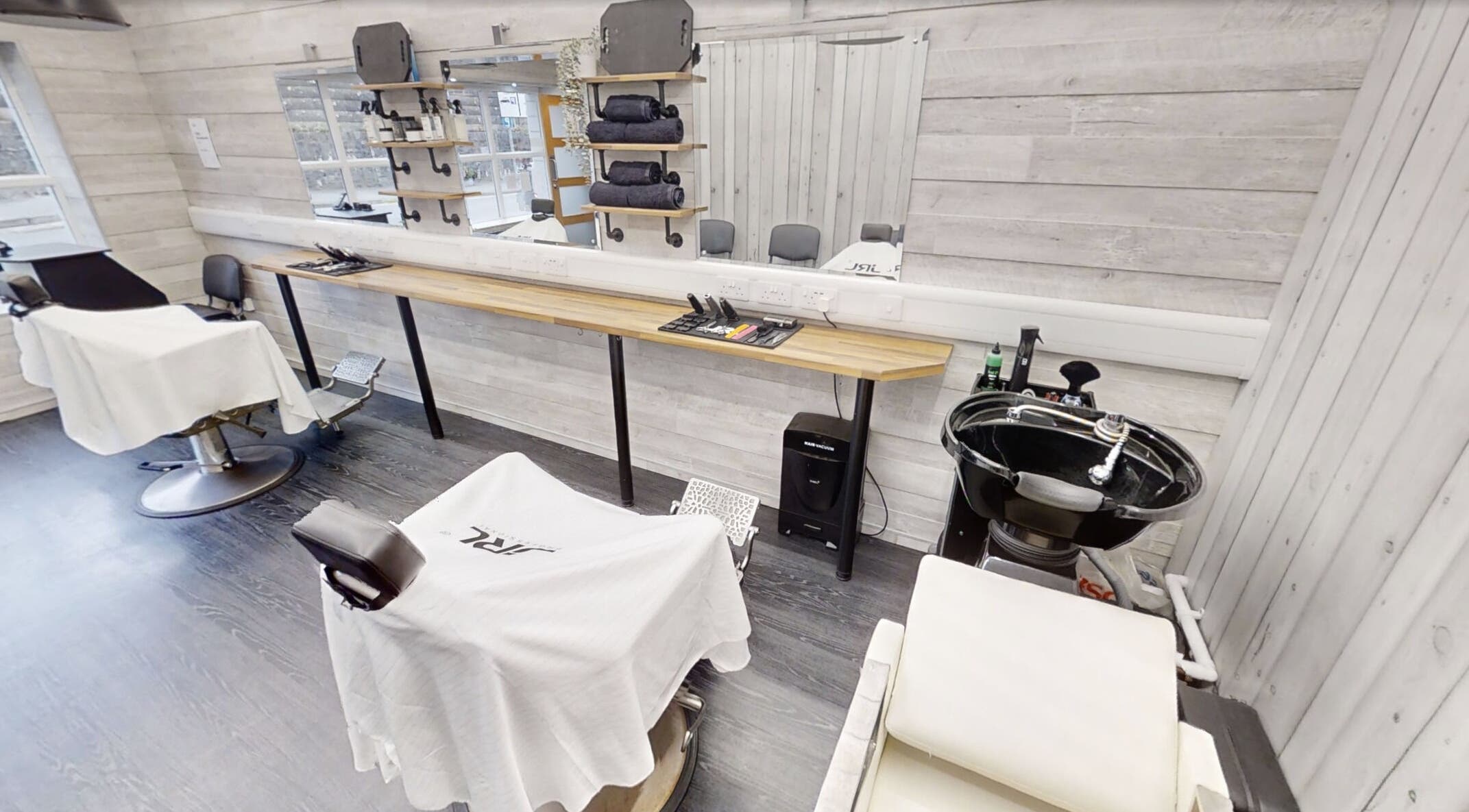Modern interior of Studio 4 Barbers in Saundersfoot, Wales, GB. Features styling stations and sleek barber chairs.