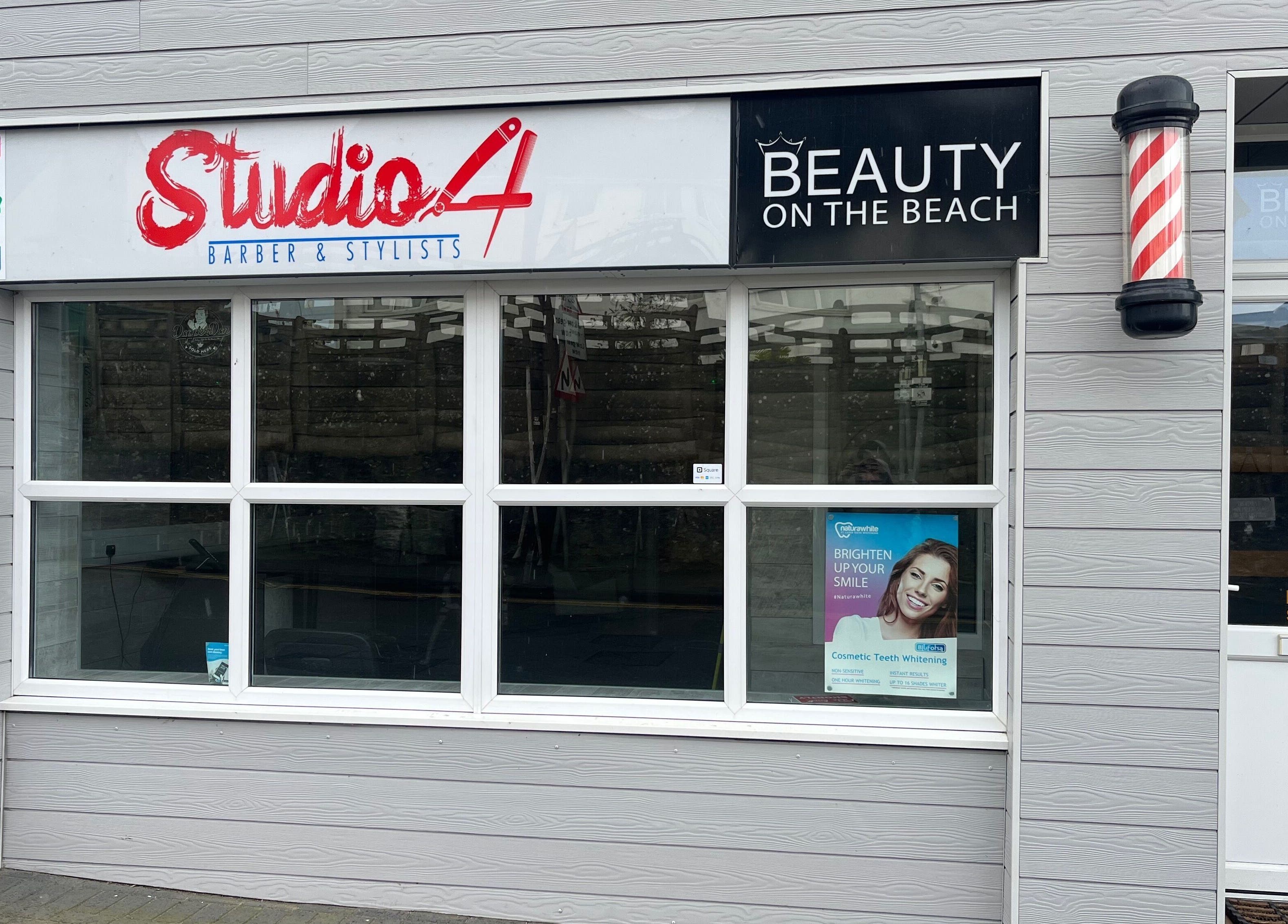 Front facade of Studio 4 Barbers, Saundersfoot, Wales, GB with stylish signage.