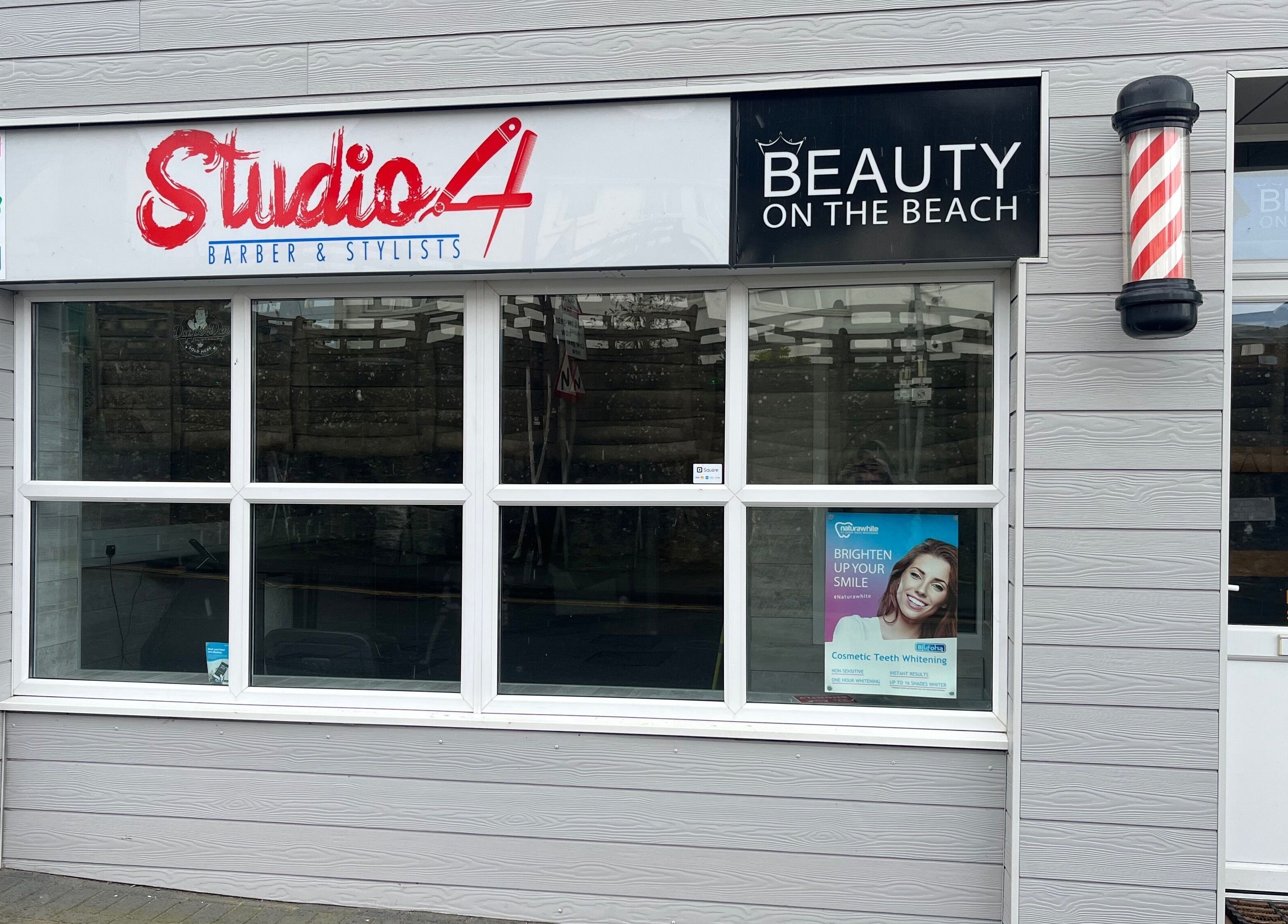 Front facade of Studio 4 Barbers, Saundersfoot, Wales, GB with stylish signage.