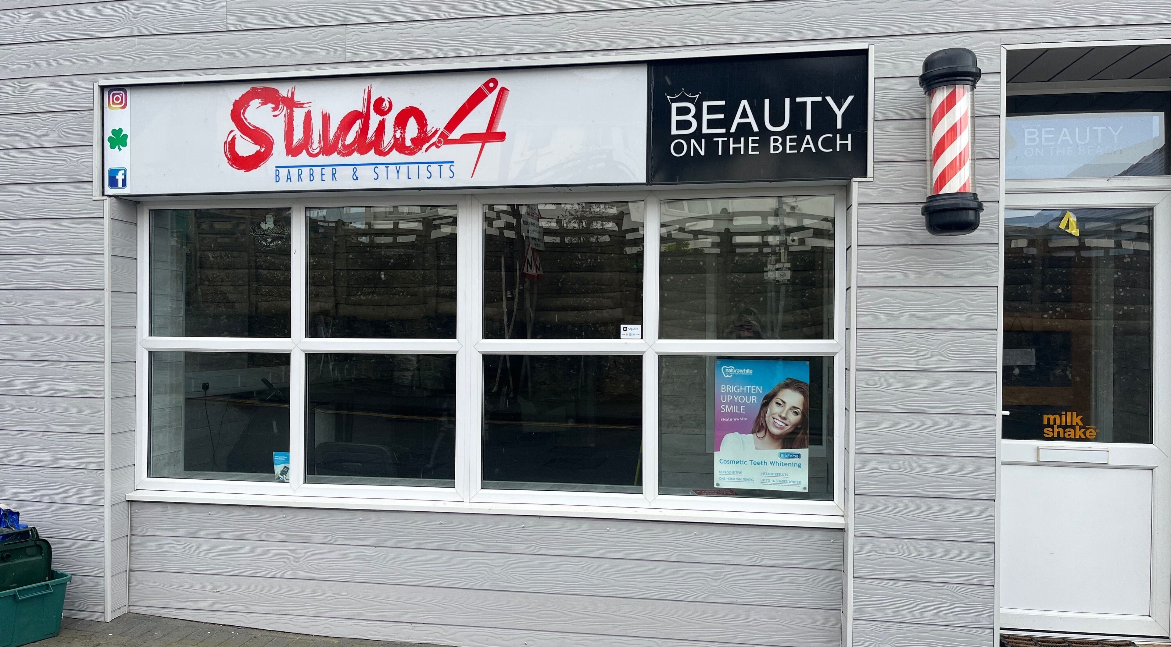 Front facade of Studio 4 Barbers, Saundersfoot, Wales, GB with stylish signage.