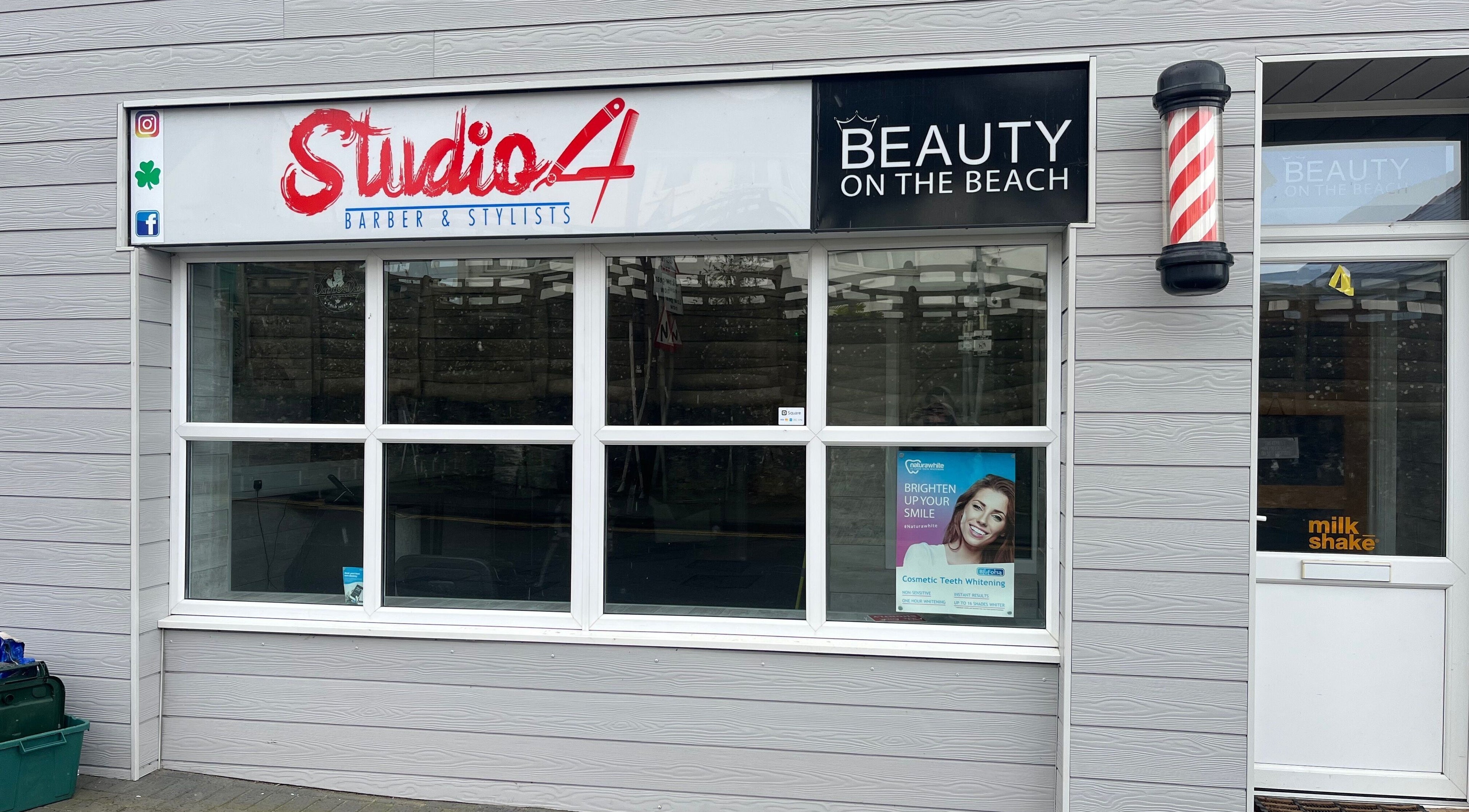 Front facade of Studio 4 Barbers, Saundersfoot, Wales, GB with stylish signage.