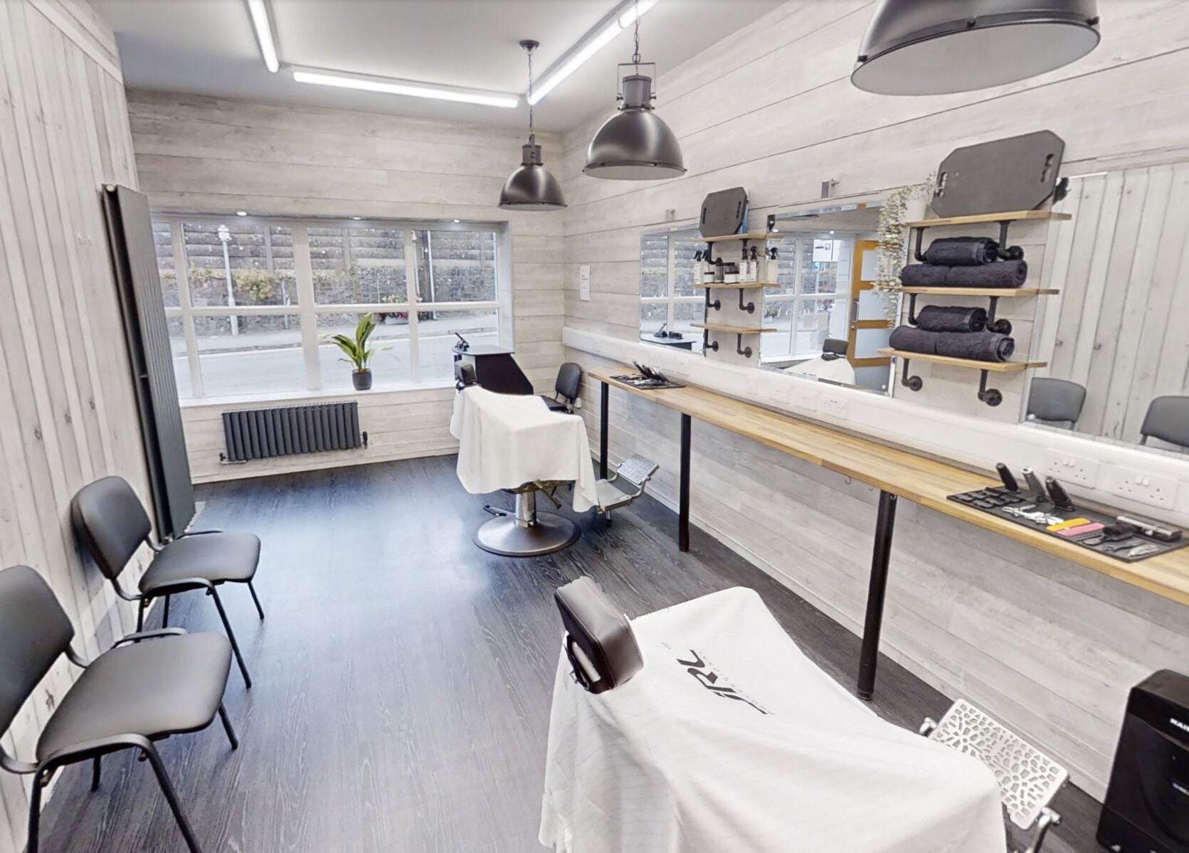 Modern barber studio at Studio 4 Barbers, Saundersfoot, Wales, GB with stylish chairs and sleek decor.