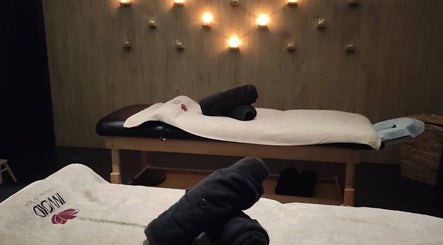 Χαλαρωτικό δωμάτιο μασάζ στο Invoid Spa, Peristeri, GR με κεριά και πετσέτες.