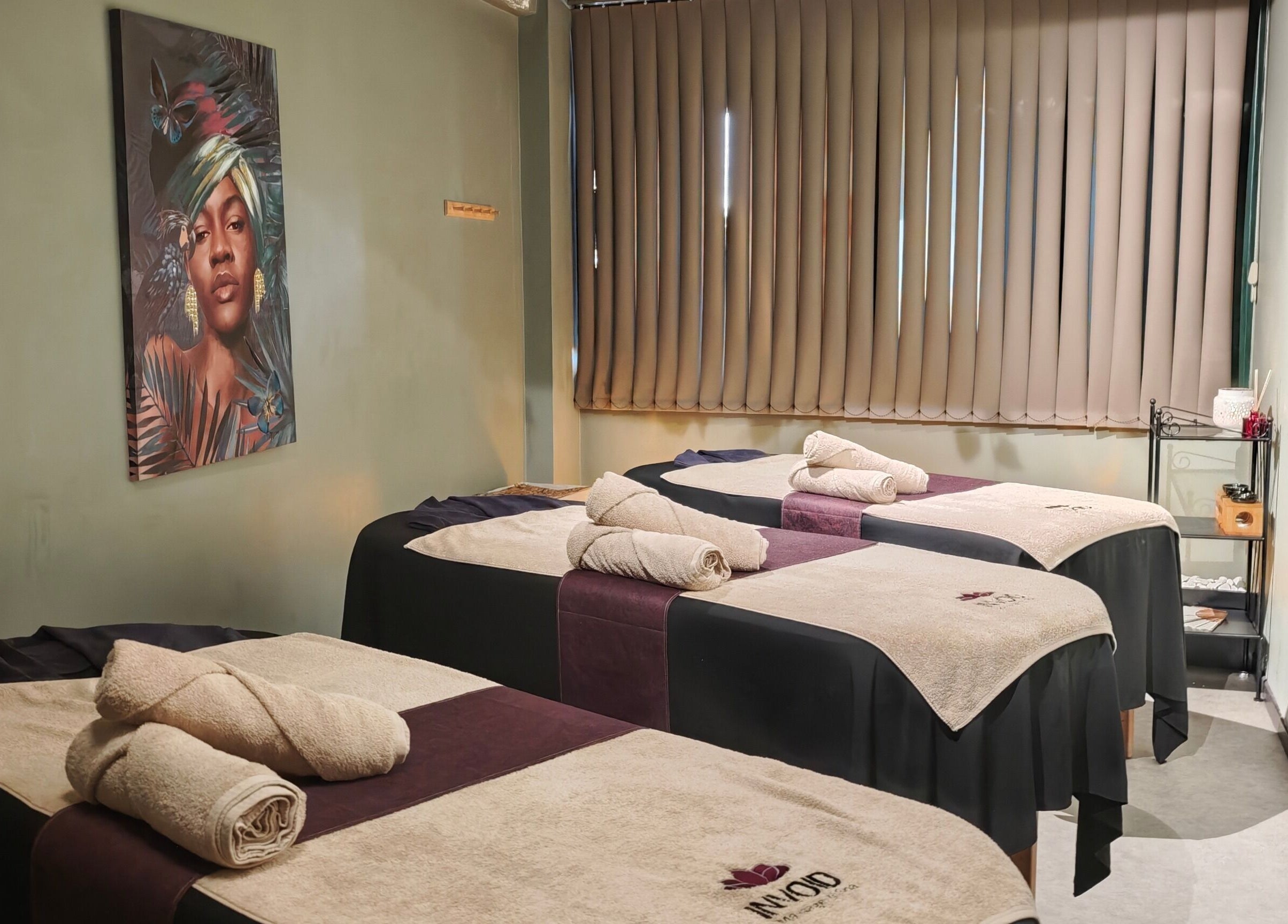 Χαλαρωτική αίθουσα μασάζ στο Invoid Spa, στο Περιστέρι, GR με τρία κρεβάτια και μοντέρνα διακόσμηση.