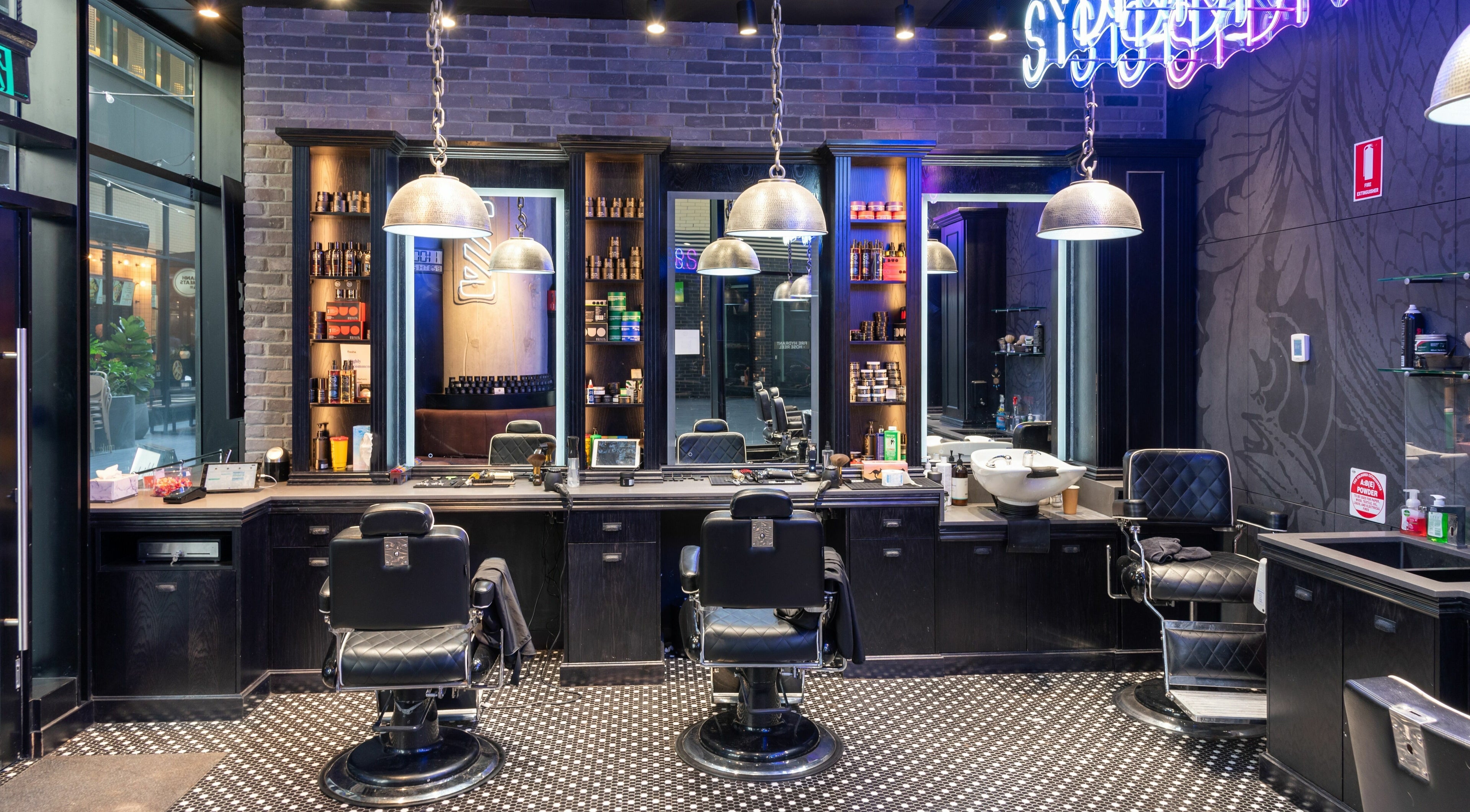 Modern interior of Sydney Barbers - Barangaroo showcasing sleek chairs and decor. Located in Barangaroo, New South Wales, AU.