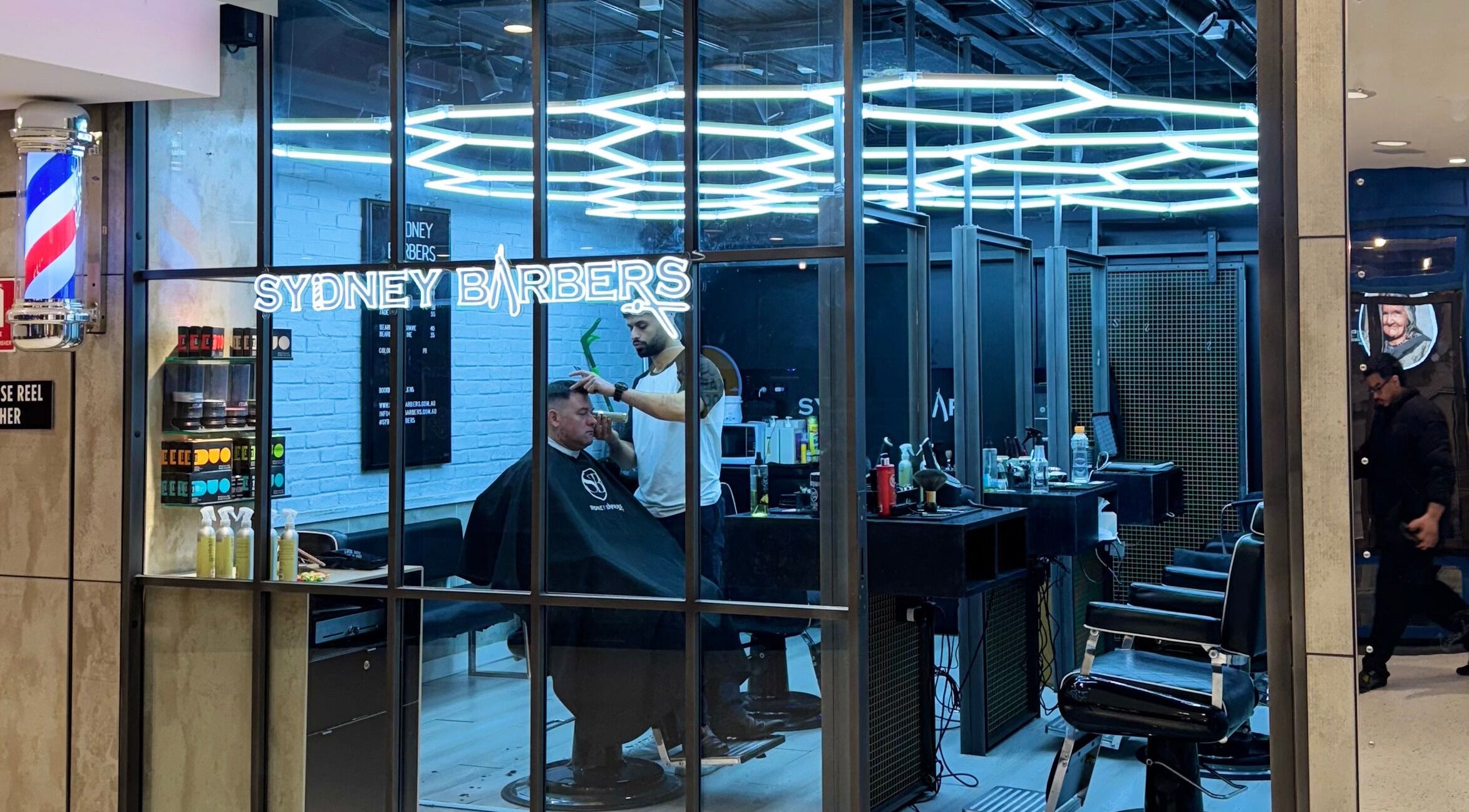 Modern barber shop at Sydney Barbers - MET Centre, Sydney, New South Wales, AU with stylish lighting and decor.