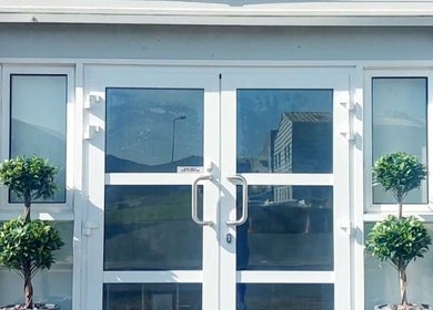 The Skin Pro .ie front entrance in Waterford, County Waterford, IE, featuring glass doors and decorative plants.