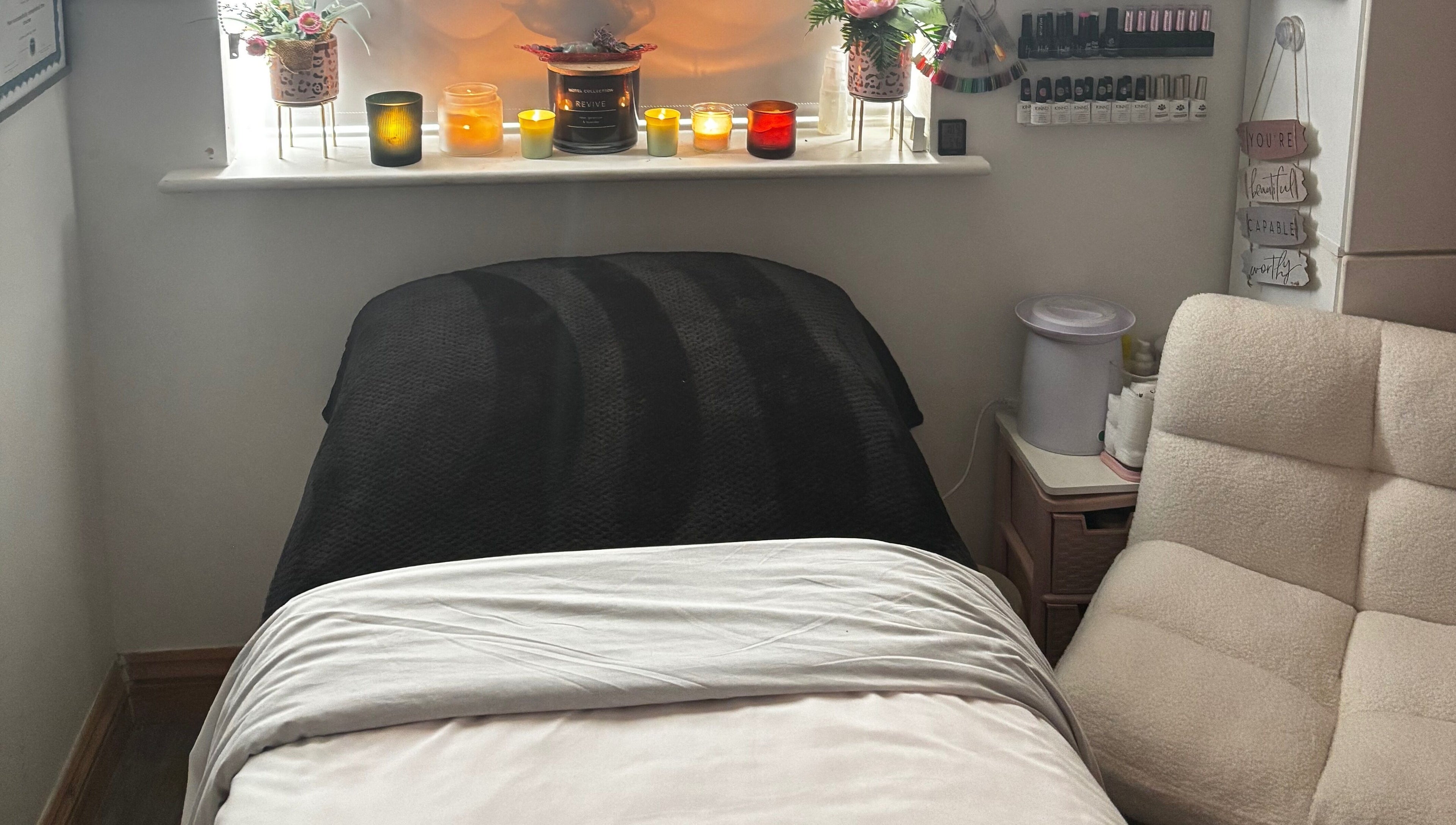 Cozy treatment room at Gemmy Gorgeous, Leeds, England, GB with candles and comfortable seating.