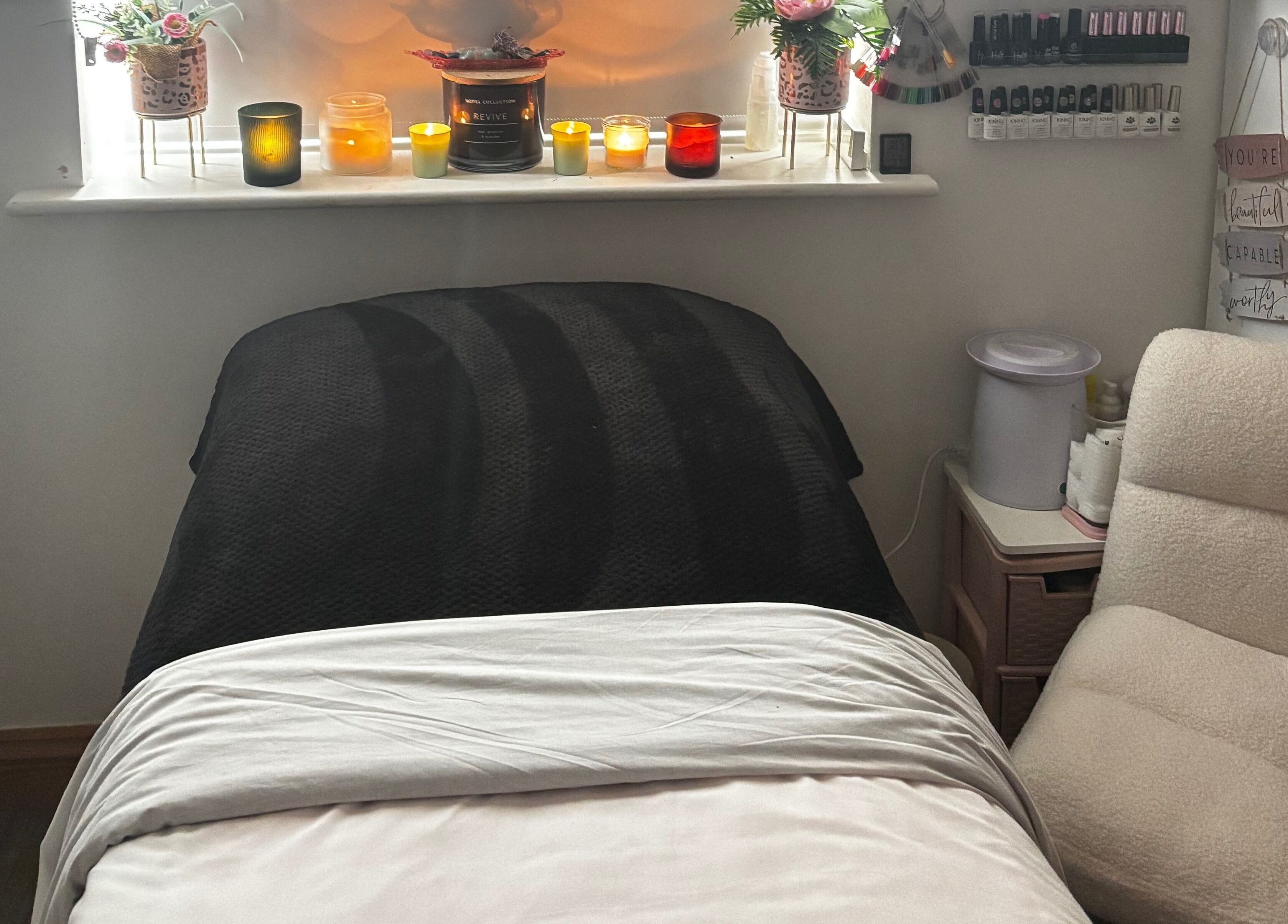 Cozy treatment room at Gemmy Gorgeous, Leeds, England, GB with candles and comfortable seating.