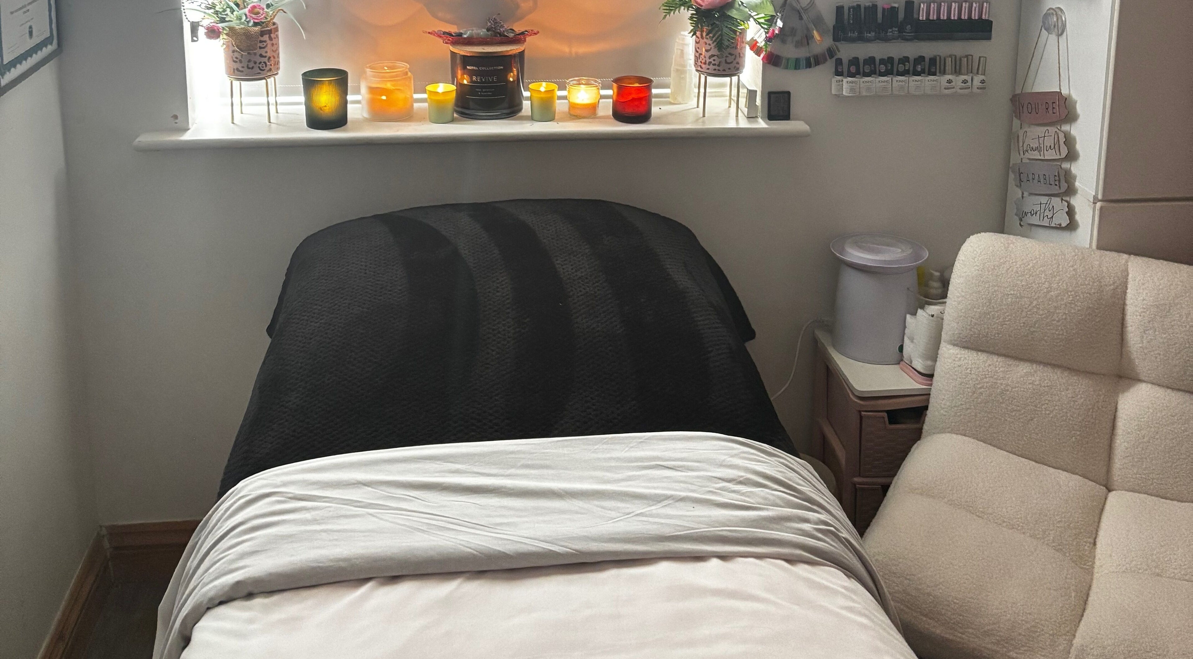 Cozy treatment room at Gemmy Gorgeous, Leeds, England, GB with candles and comfortable seating.